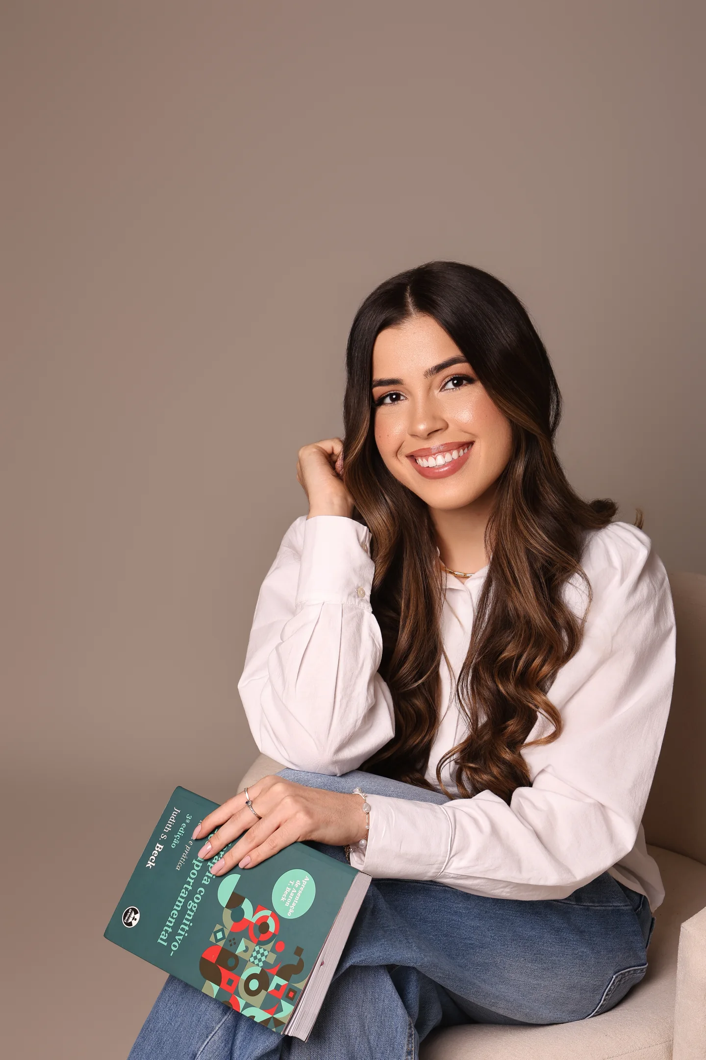 Vitória Lara com um livro em um ambiente acolhedor
