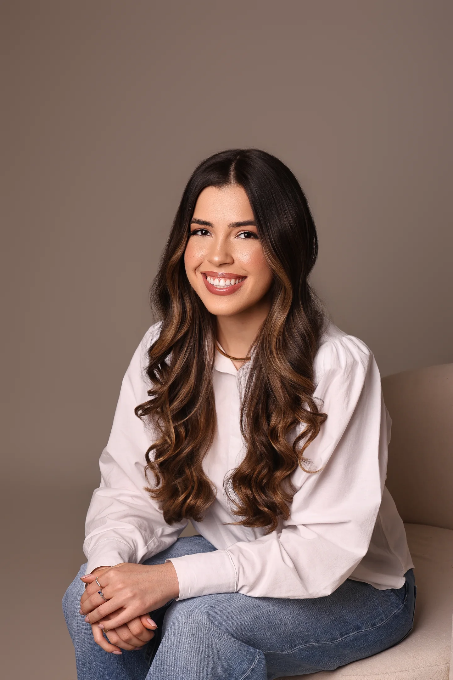 Vitória Lara sorrindo, sentada em uma poltrona